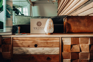 In view: A beautiful and unique, hand-crafted Salt Lamp placed on an eleganet wooden table in an indoor setting